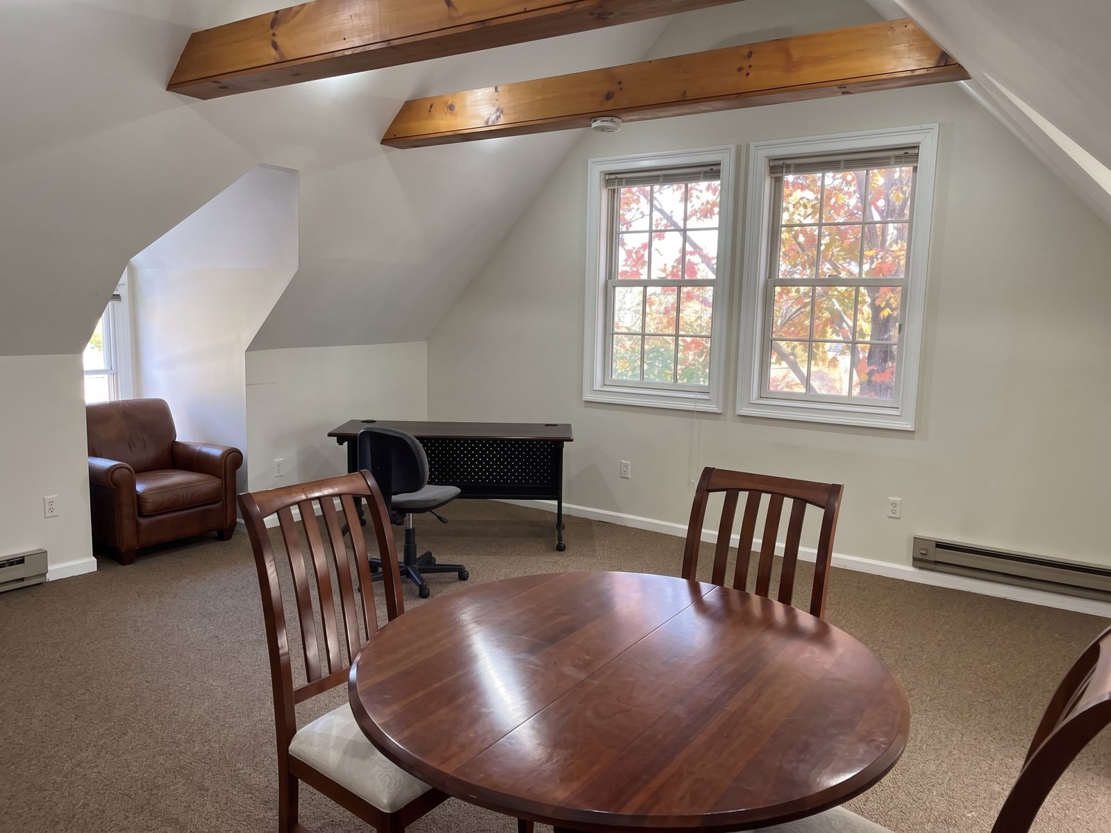 Second floor room with exposed wood beams and dormer windows